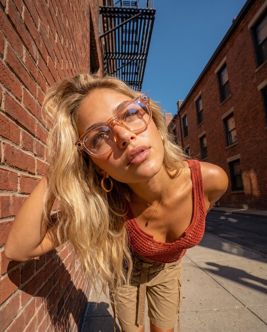 Model leaning against a brick wall in an alley
